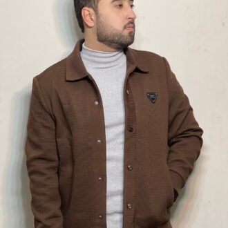 A Man in a grey mock-neck, inner-layered with a brown jacket for a Casual look.